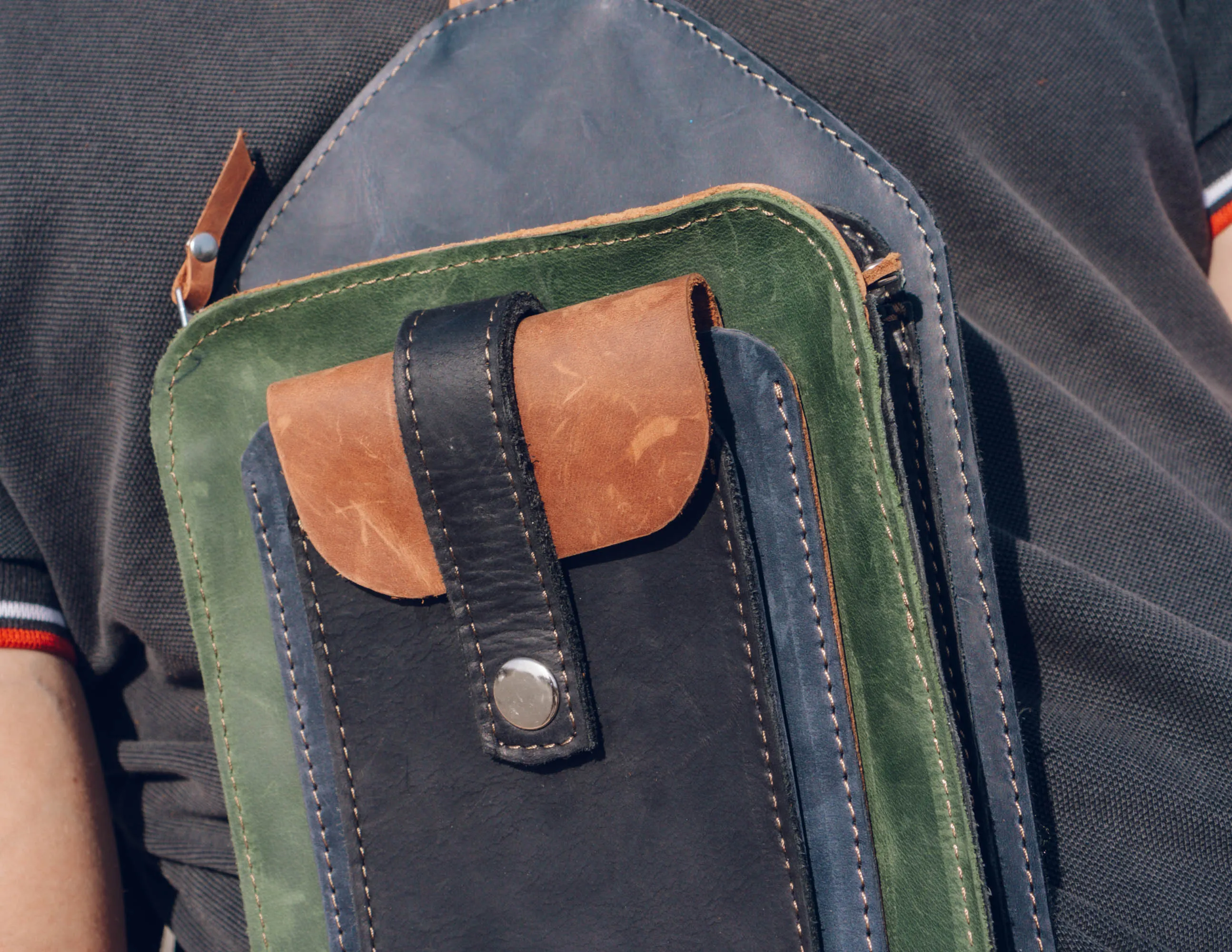 Men's crossbody bag featuring green, brown, blue, black leather and multiple pockets